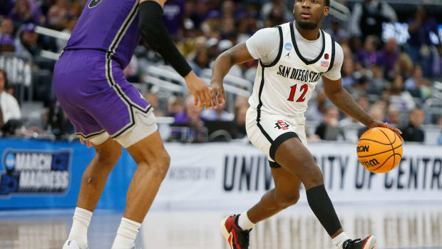 San Diego State Aztecs guard Darrion Trammell dribbles against Furman Paladins guard Mike Bothwell.